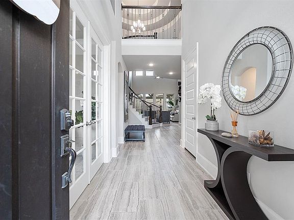 Walking into this gorgeous home you get a feel of just how grand everything is. This space showcases soaring high ceilings, recessed lighting, open spaces and fluid floor plan, custom cool paint, stunning second floor balcony overlooking the living r