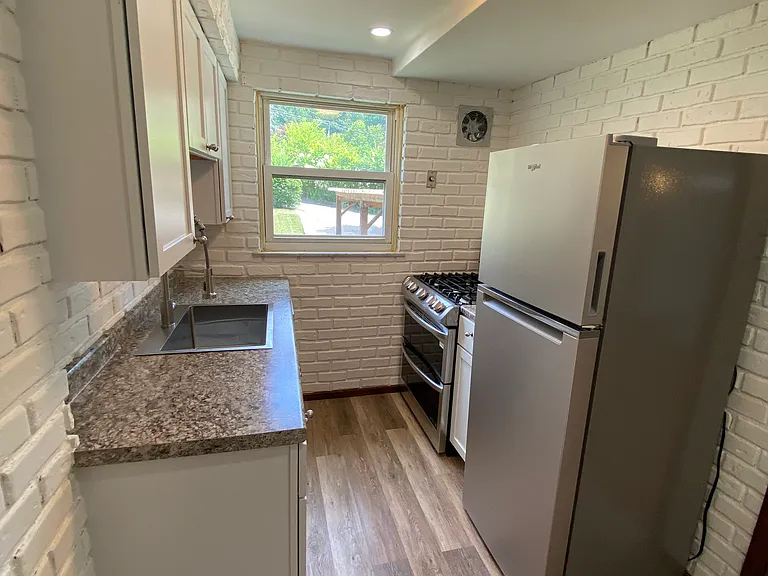 Kitchen has new appliances, cabinets, and vinyl plank flooring