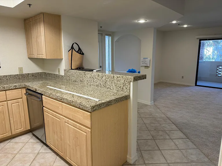 Another view from the kitchen shows a decorative arched opening between the entrance and the dining area. You can put two bar stools at the Kitchen counter. Perfect set-up for friends or a quick snack.