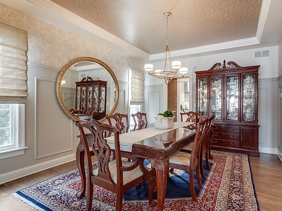 Formal Dining Room with Hardwood Floor, Tray Ceiling, Custom Moldings and Custom Wall Sconces