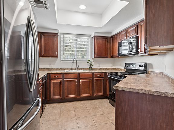 Nice kitchen with reset lighting above, microwave, oven, dishwasher and side by side fridge