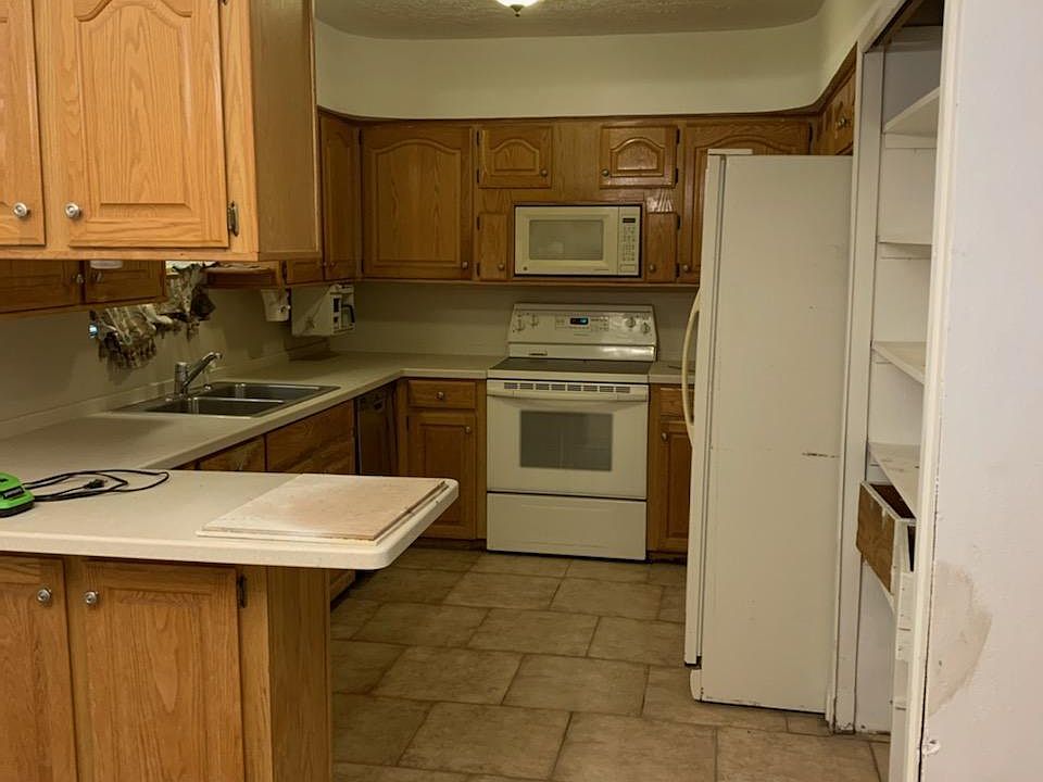 Spacious kitchen with plenty of cabinet storage & ceiling tall food storage pantry.