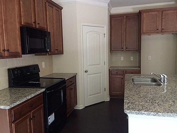Kitchen has granite tile counter tops, black appliances!