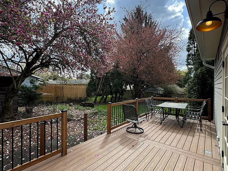 Large deck overlooking back yard, magnolia and flowering cherry trees.