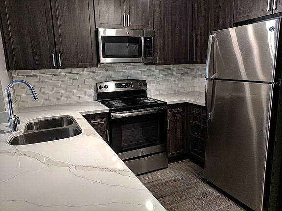 Upgraded kitchen with espresso cabinets with tile backsplash
