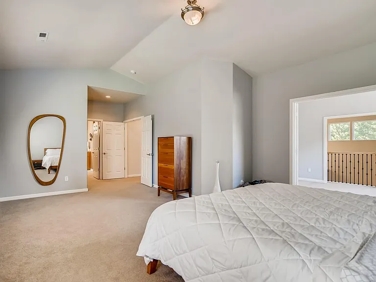 View of the master entry door along with the den with a balcony that overlooks the living room