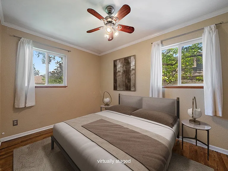 2nd of 2 bedrooms (NW corner to backyard) with ceiling fan. Virtually staged photo.