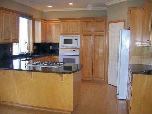 Kitchen w/ maple flooring and cabinetry. granite couters