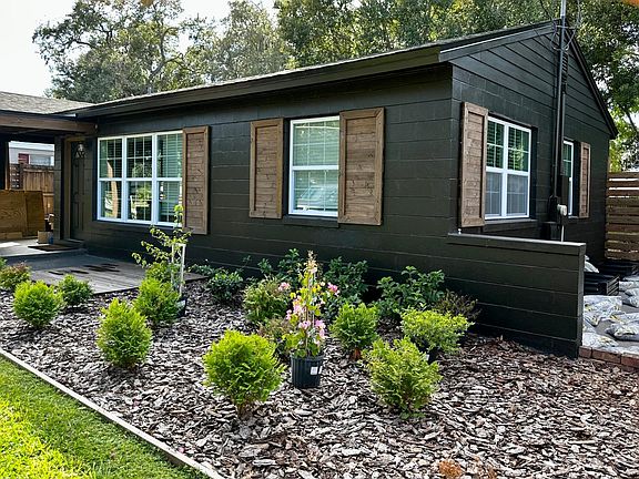 VERY UNIQUE designer black paint with wood accent exterior design and new lush landscaping! Side of home has a raised garden staging area that is brand new and ready for planting.
