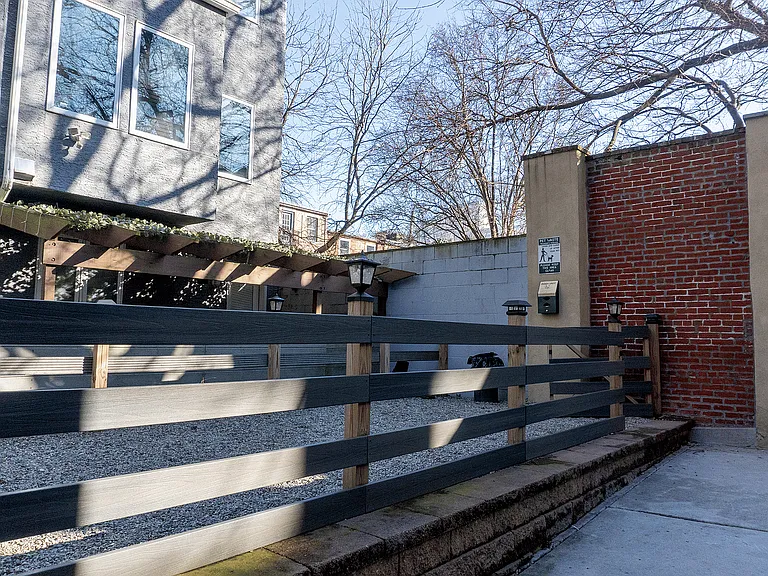 Experience tranquility in this delightful courtyard, featuring stylish fencing and lush greenery.