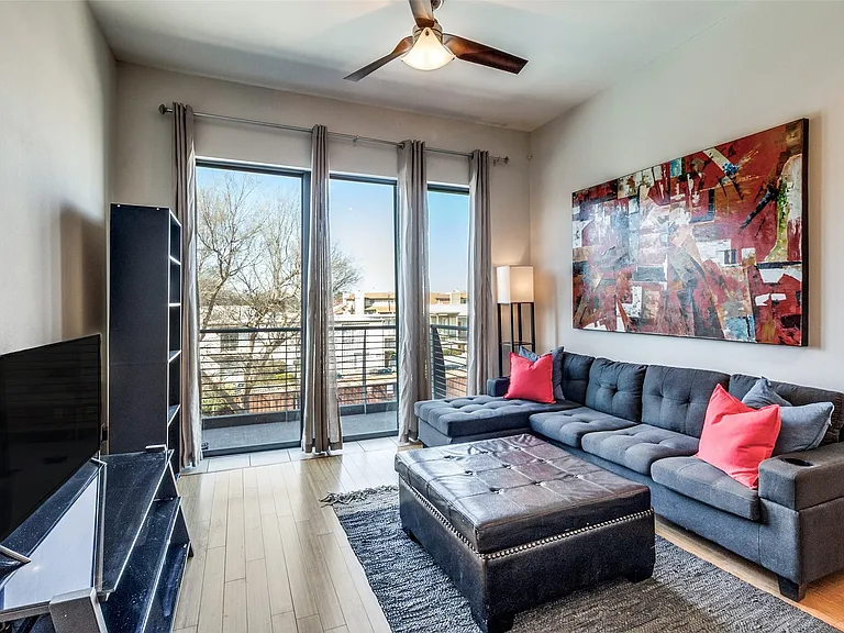 Open living area with large, bright windows and balcony.