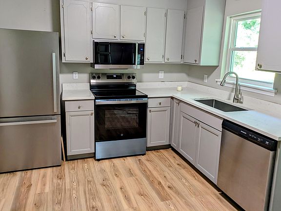 Kitchen with a new microwave and stove.