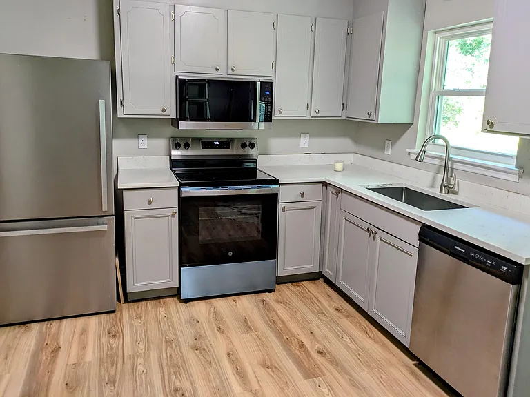 Kitchen with a new microwave and stove.