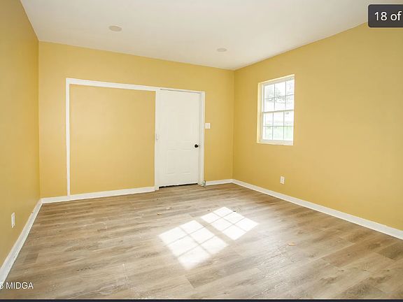 Sun-filled room with neutral tones and cozy carpeting, offering a warm and inviting space that's easy to personalize.