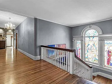top of staircase on 2nd floor bedrooms showing large stained glass window