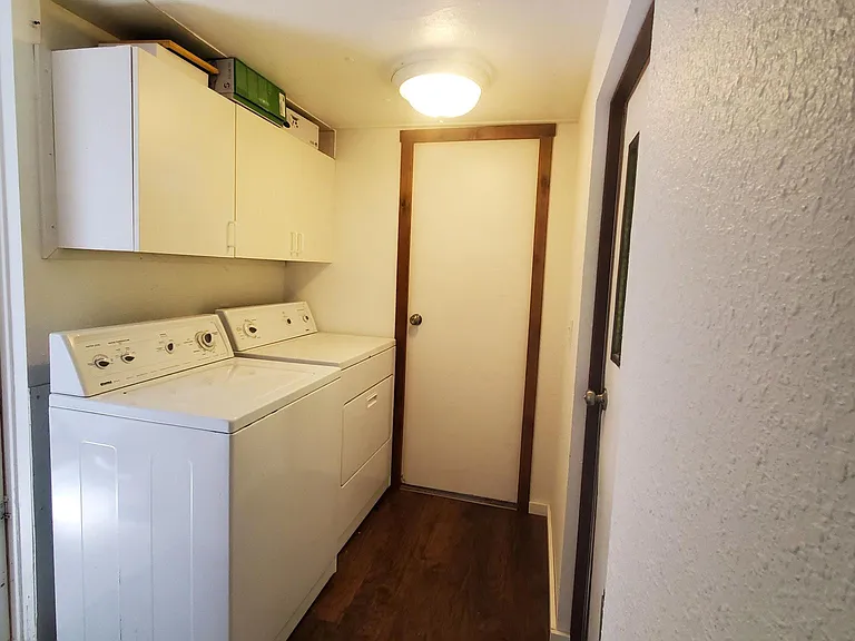 Washer and dryer located off hallway.