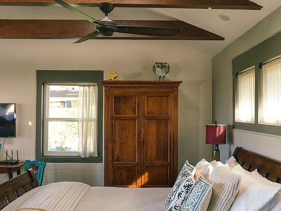 Armoire, queen bed, skylight and beams above.