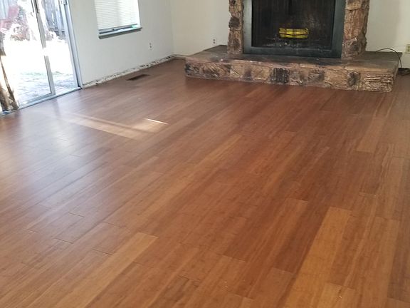 large family room with bamboo wood floors and fireplace . overlooking yards