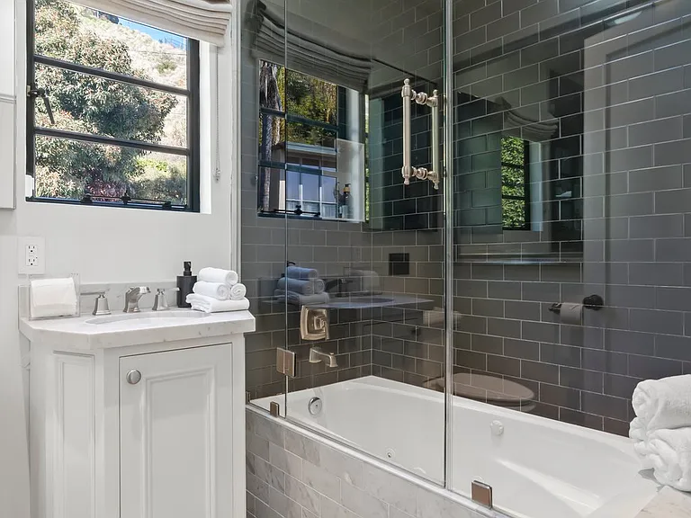 Indulge in a deep soaking tub with a sleek glass-enclosed rain shower.