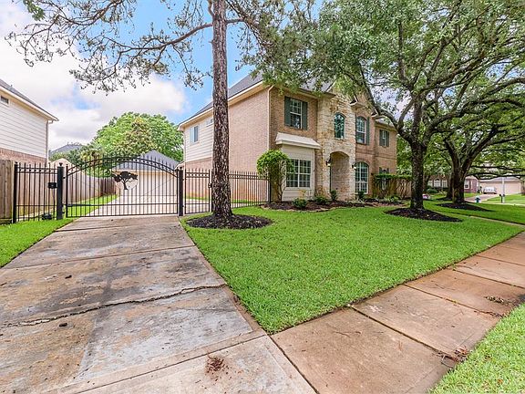 A expansive driveway leads up to a detached garage! The custom iron gate adds extra security and privacy!