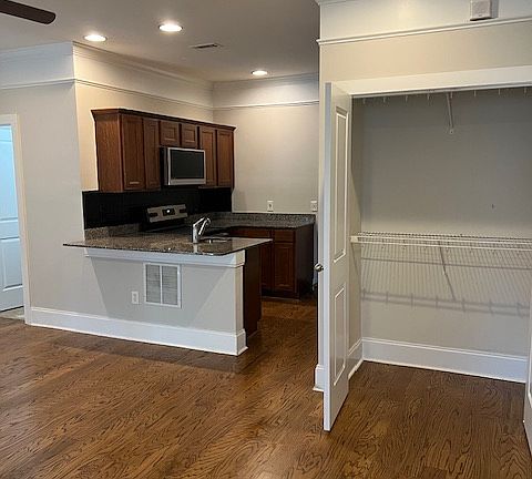oversized closet with multiple hanging bars just off the main room and conveniently next to open concept kitchen