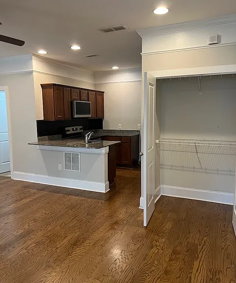 oversized closet with multiple hanging bars just off the main room and conveniently next to open concept kitchen