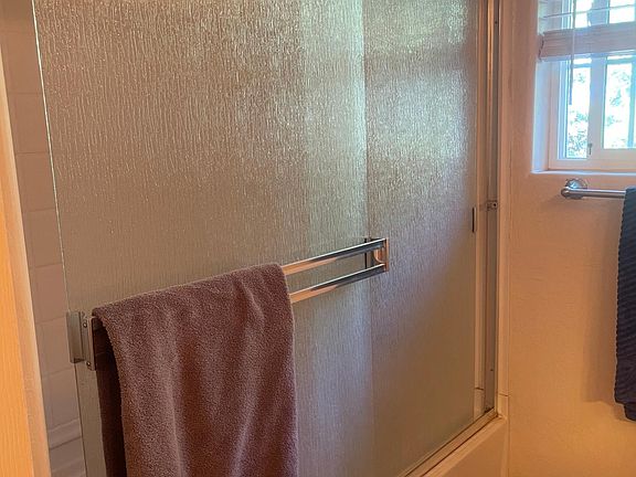 Smart tv mounted on swivel mount. Brass top bar, broom closet with vacuum and storage.