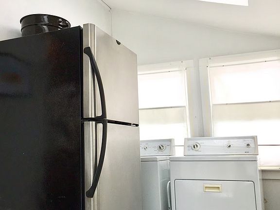 Stainless steel refrigerator and laundry machines on sunporch