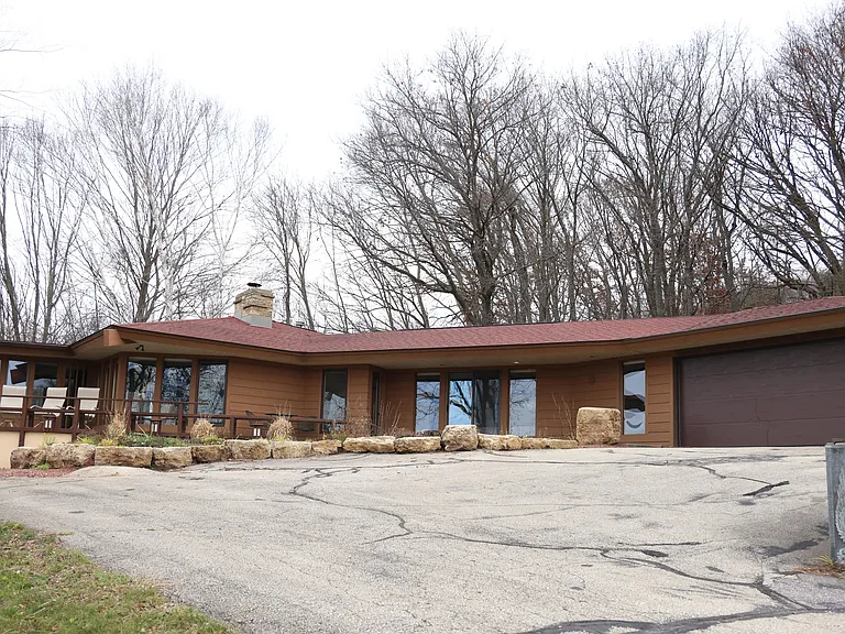 This beautiful mid-century modern home has a welcoming wraparound porch and large windows to take in the views.