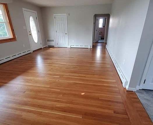 Large living room with fireplace, coat closet and bay window.