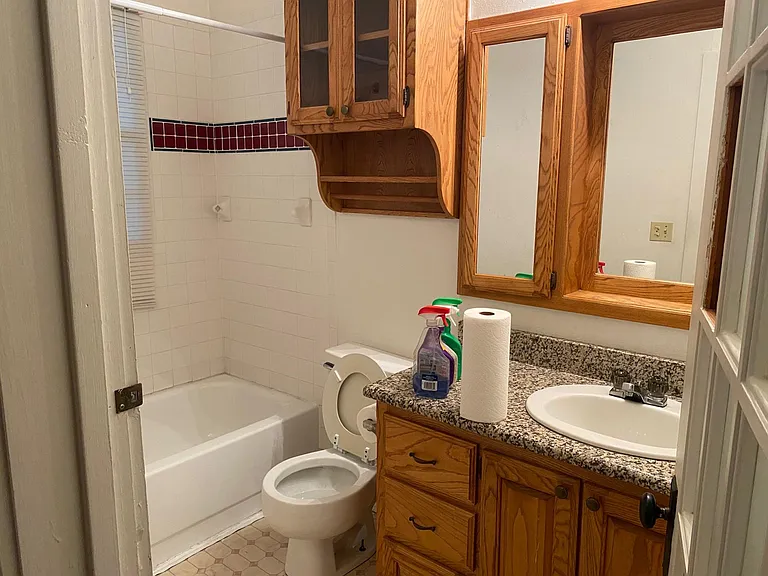 Master Bathroom - Wooden cabinets, mirrors, granite countertops, vinyl flooring.