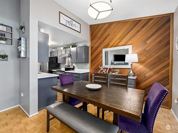 The spacious dining room boasts a stylish wood accent wall.>