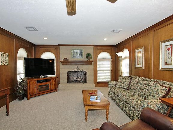 Beautiful, arched windows overlook the front landscape and add an elegant ambiance to the gas-log fireplace.