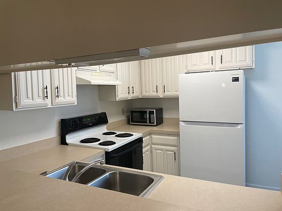 kitchen has eat in bar, microwave, range and refrigerator
