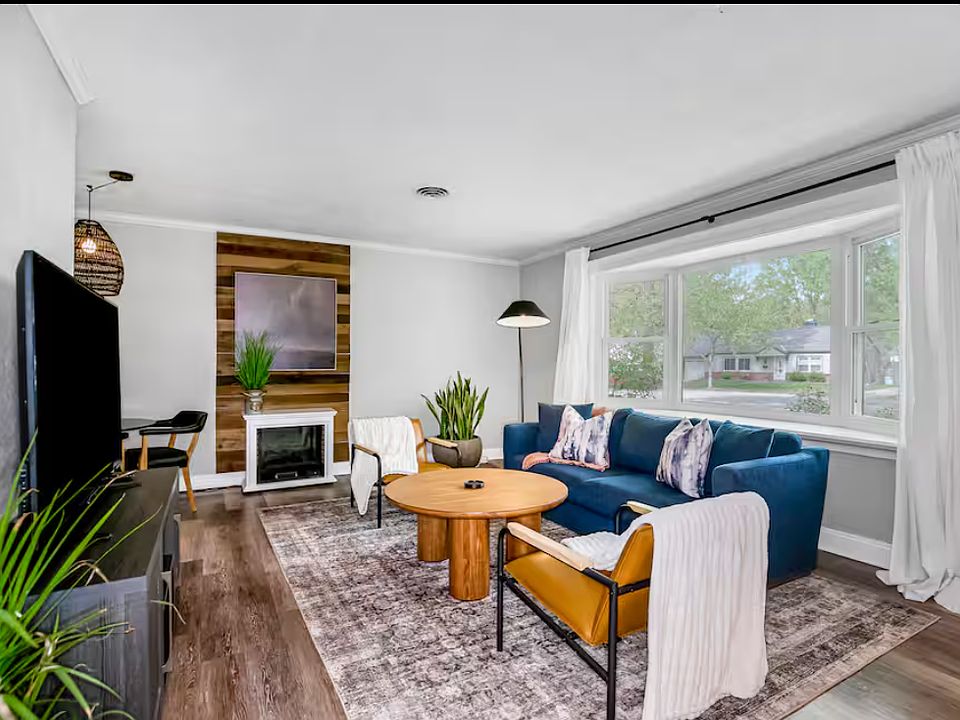 Stylish living area with natural light & modern furnishings. Couch is situated in front of a large bay window looking out onto mature tree-lined, quiet street.