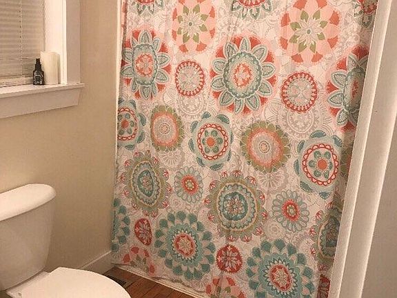 Clean bath with hardwood flooring