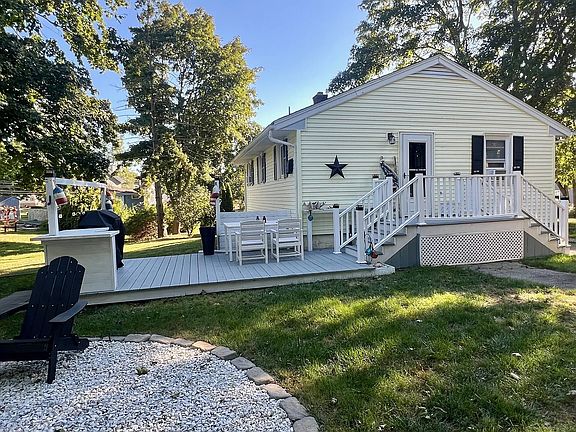 Private backyard oasis with a grill, dining area, fire pit, and plenty of cozy Adirondack chairs.