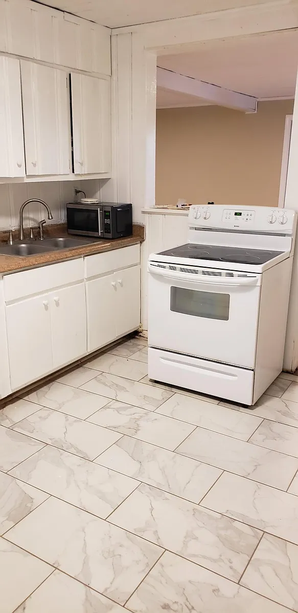 Stove and sink with main room in background. - Grandview Ave NE