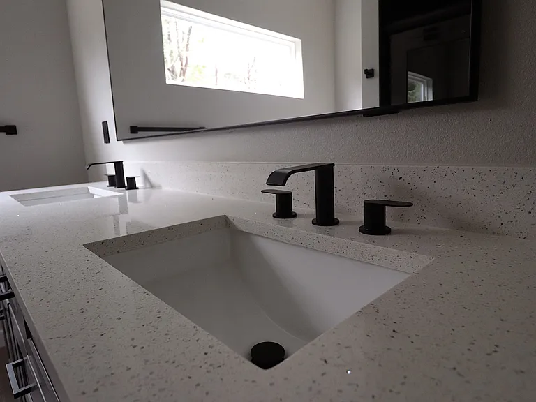 Modern primary bathroom featuring double vanity with quartz countertops, sleek fixtures, and excellent lighting. Clean, contemporary design.
