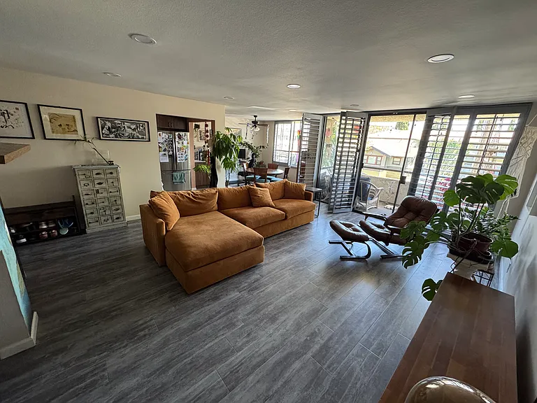 Living room feature 3x3 LED overheard lighting on a dimmer switch and laminate board hard flooring.