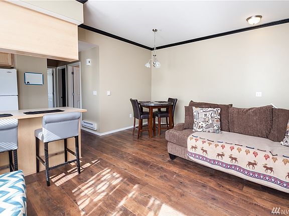 There is a dining room/eating nook with an overhead light fixture in the corner, and the kitchen counter features an eating bar.