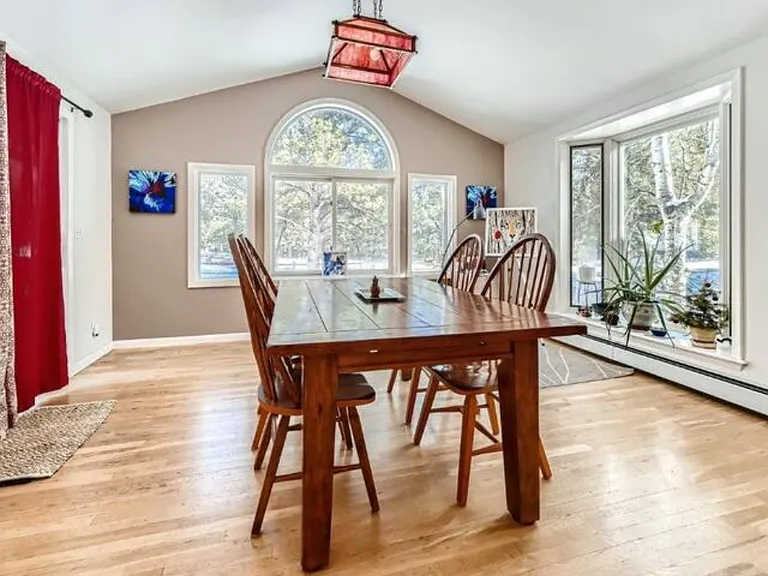 Large dining room with large windows, lots of light, perfect for dinner gatherings, spaces to study work or create.