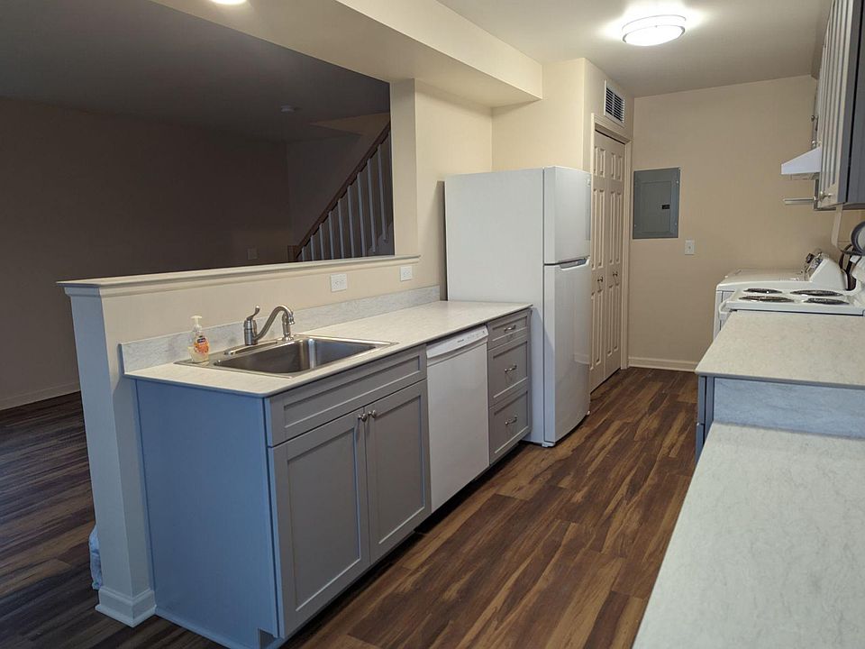 Kitchen from eating counter looking into living room. Sink has garbage disposal. Dishwasher and refrigerator. Closet holds gas furnace and 40-gal. water heater.