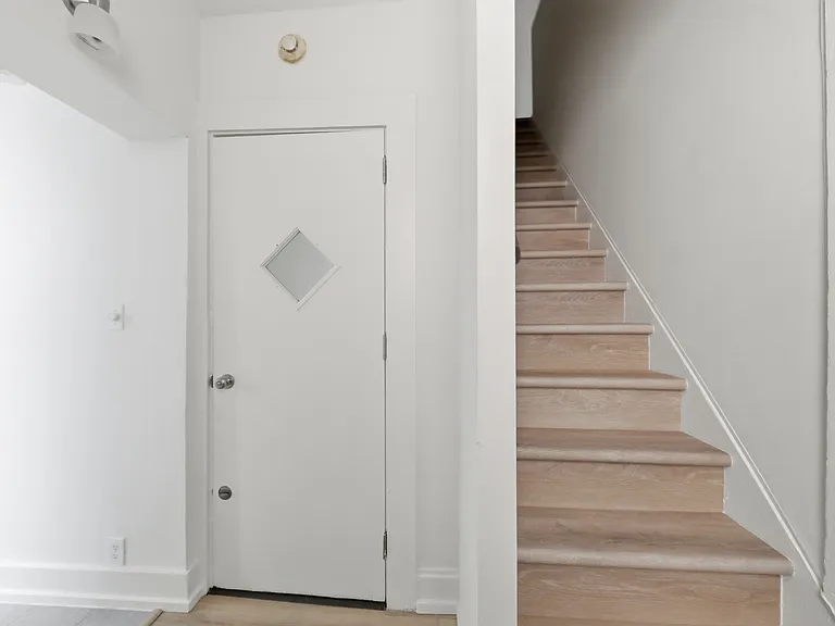 Door is to stairs down to entry. Stairs on right lead to upstairs.