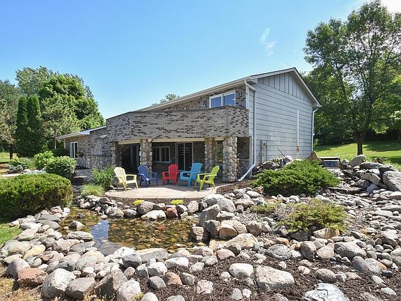 water feature in front of the home has a water fall and pond