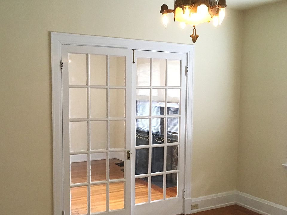 Dining room with chandelier and hardwood floors.