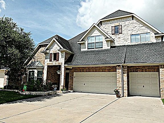 LUSH LANDSCAPING LEADS YOU TO THE CHARMING COVERED FRONT PORCH.