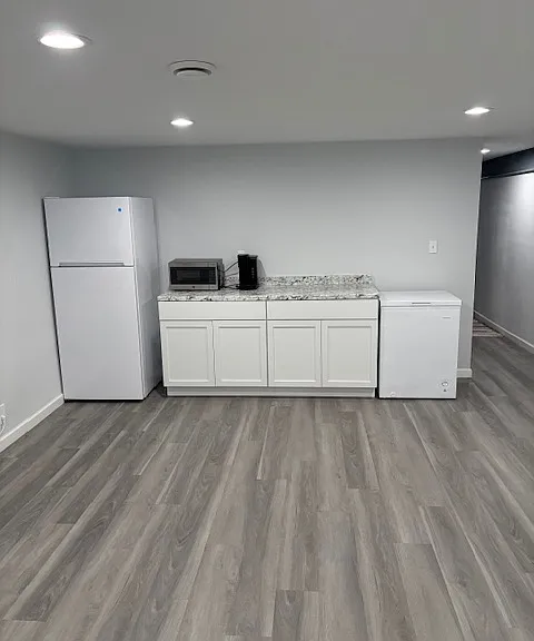Kitchenette in rec room with fridge, microwave, Keurig coffee maker, and chest freezer.