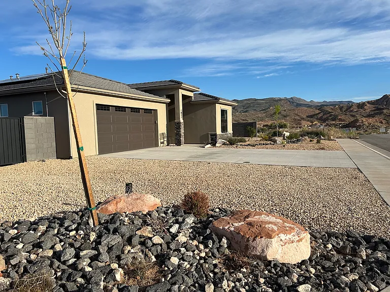 Front side yard showing access through gate to left of garage for RV storage
