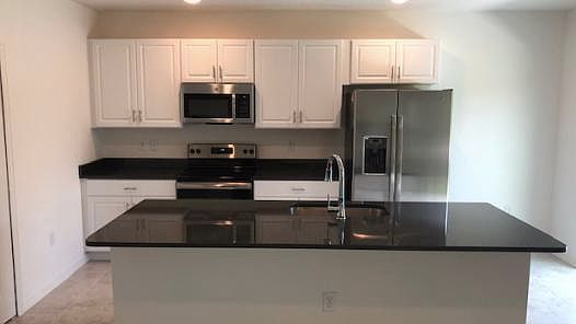 Modern open concept kitchen with upgraded white cabinets and